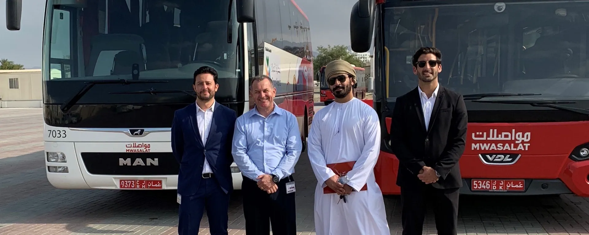 Joaquín Pena en Omán, donde trabajó en la optimización de transporte público. Joaquín Pena junto a tres personas delante de unos ómnibus en Omán.