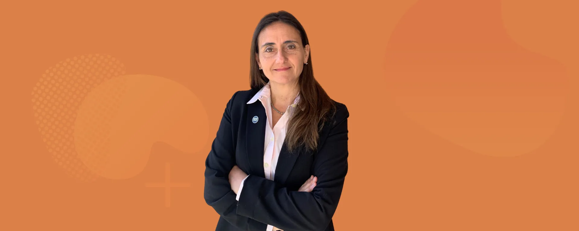 Carolina Saizar, posa sobre fondo color naranja