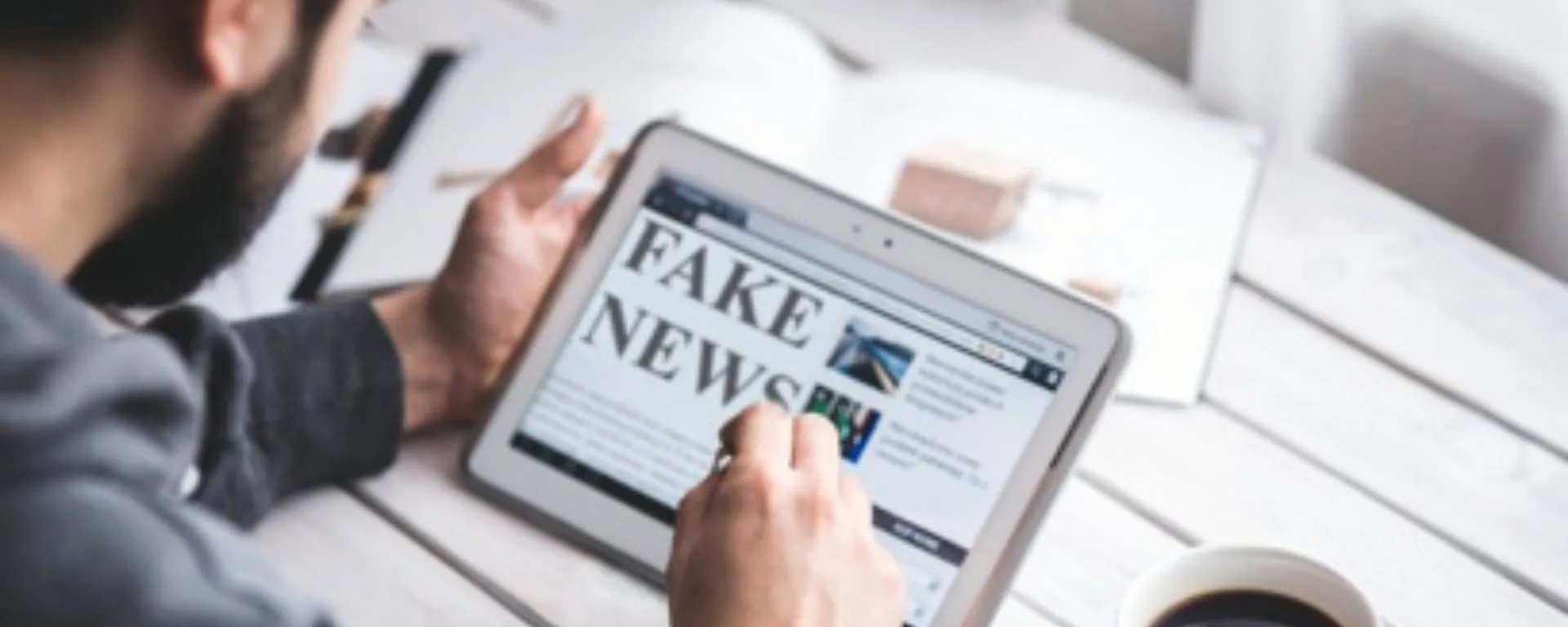 Chico con tablet que lee: "Fake News" Chico con tablet que lee: "Fake News"