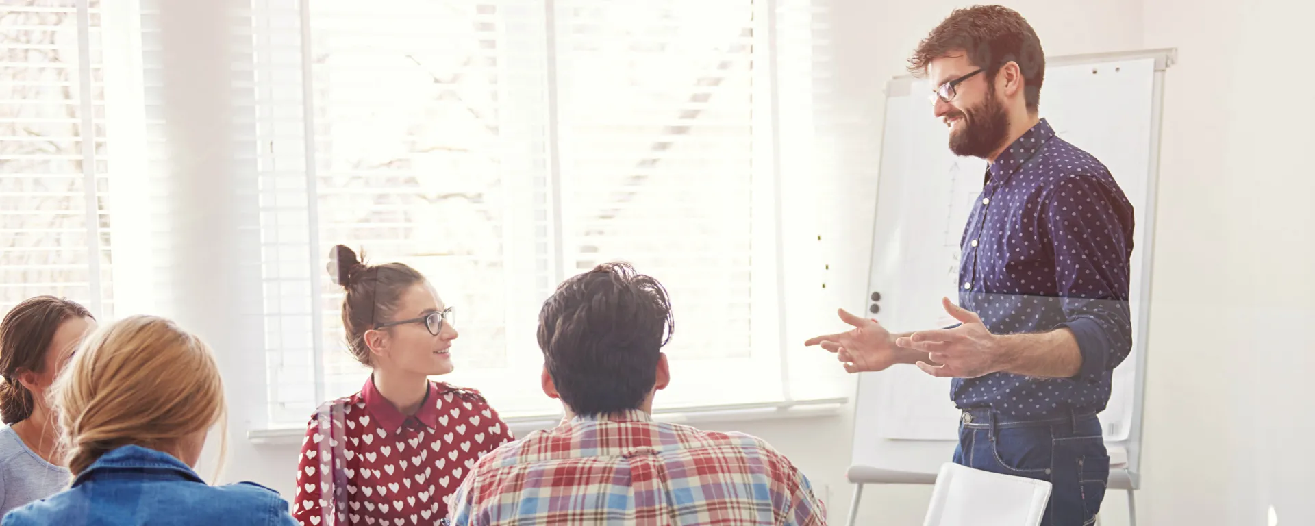 docente hombre impartiendo clases a estudiantes universitarios en una mesa amplia. Alumnos con laptops. docente hombre impartiendo clases a estudiantes universitarios en una mesa amplia. Alumnos con laptops.